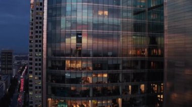 Günbatımı gökyüzünü yansıtan parlak cam cepheli modern fütüristik ofis binasının yükselen görüntüleri. Varşova, Polonya