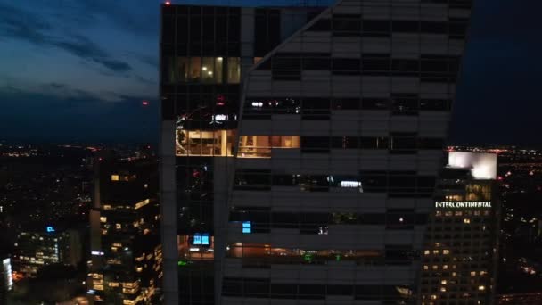 Flyg runt modern futuristisk skyskrapa med blank glasfasad. Panoramautsikt över nattstadsbilden. Warszawa, Polen — Stockvideo