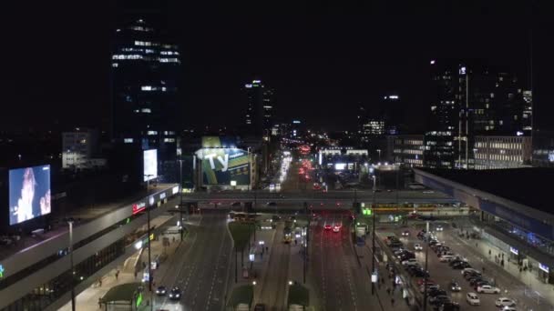 Do tyłu latać nad szeroką ulicą prowadzącą wokół budynku głównego dworca kolejowego. Wieczorne korki w centrum. Warszawa, Polska — Wideo stockowe