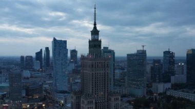Kültür ve Bilim Sarayı alacakaranlıkta. Şehir merkezindeki yüksek binalar. Eski ve modern yüksek binalar arasındaki zıtlık. Varşova, Polonya
