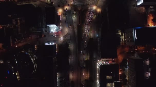 Pájaros aéreos ojo arriba arriba abajo panorámica vista del tráfico alrededor de la intersección. Coches conduciendo por la ciudad nocturna. Varsovia, Polonia — Vídeo de stock