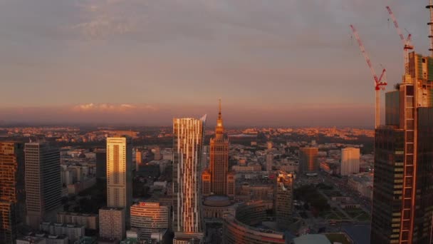 Scorrevole e filmato pan di edifici del centro di grattacieli negli ultimi raggi di sole del giorno. Storico edificio PKIN al tramonto. Varsavia, Polonia — Video Stock