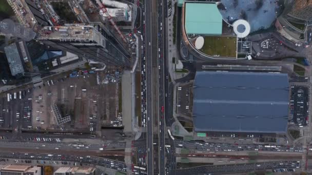 Volatili aerei occhio sopra la testa verso il basso panoramica vista del traffico nelle strade che portano lungo grattacieli alti. Gru in cantiere. Varsavia, Polonia — Video Stock