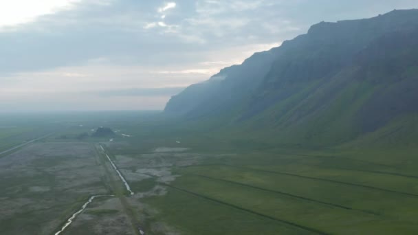 Vertical aerial drone view of haze panorama of Iceland green countryside. Amazing in nature. Birds eye stunning view of foggy landscape in southern icelandic highlands — Stock Video