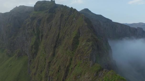 Légi kilátás mohos sziklás hegygerinc a ködös hegyekben Izlandon. Madarak kilátás ködös és felhős csúcs panoráma déli jéghegyvidéken — Stock videók