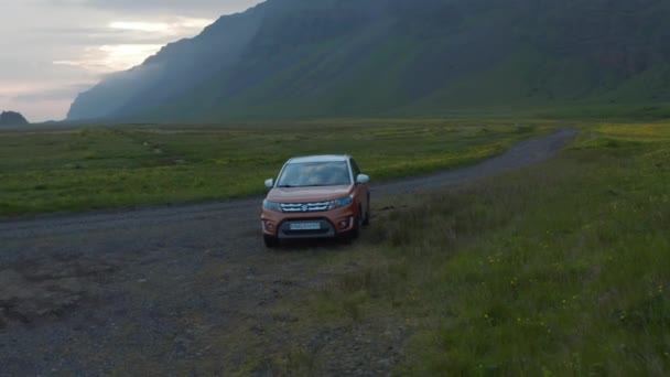 アイスランドの芝生の田舎に駐車航空ビュー車。冒険的な探検のために駐車車でアイスランドの高地のドローンビュー — ストック動画