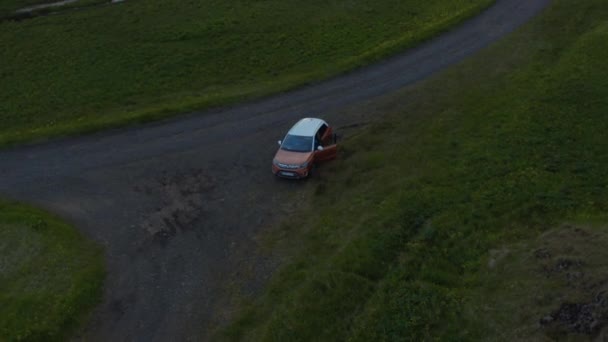 İHA görüntüsü güney İzlanda 'da park edilmiş off-road arabasının kırsalına iniyor. İzlanda 'nın dağlık kesimlerinde park etmiş, tatil boyunca vahşi doğayı keşfeden 4' e 4 araçlık kuşların gözü. — Stok video