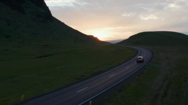 晚上在黄金时段平平安安地驾驶公路车辆的无人机画面。鸟瞰汽车在冰岛最重要的公路环路上快速行驶 — 图库视频影像