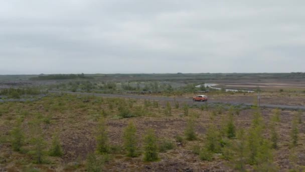 Drone vista girando lentamente sobre Ring Road en Islandia revelando un paisaje impresionante. Vista aérea del coche que conduce en la carretera más larga de Islandia que permite llegar a todas las regiones de la isla — Vídeo de stock