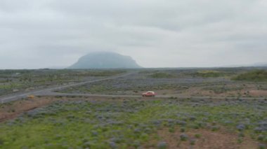 Çevre yolunda giden hava manzaralı araç, otoyol 1. Yol ve İzlanda 'nın tüm bölgelerine ulaşmamızı sağlayan ana cadde. Volkanik arazide araba sürüşünün insansız hava aracı görüntüsü