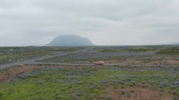 環状道路を走行する空中ビューカー、高速道路はルート1であり、アイスランドのすべての地域に到達することができますメインストリートです。火山の風景を横断する車のドローンビュー — ストック動画