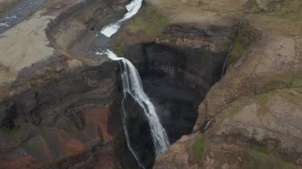 Flygfoto över Haifoss vattenfall kraschar mot klipporna på Island. Ovanifrån av Haifoss, Islands näst högsta vattenfall. Vattenfall vid floden Fossa — Stockvideo