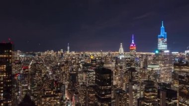 Gece şehir merkezinin üzerinde uç. Yüksek binalarda yüksek hızda aydınlanma. Manhattan, New York City, ABD