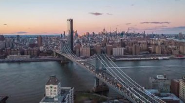 İleri, Manhattan köprüsünün üzerinden uçar. Yollarda ve suda yoğun trafik var. Gökdelenleri pembe alacakaranlık gökyüzüne karşı. Manhattan, New York City, ABD