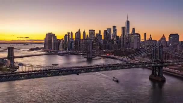 Вечірня гіперлапсія великого сучасного міста. Лети над мостами і дивитися на хмарочоси у центрі міста проти тьмяного заходу сонця. Бруклінський міст у Манхеттені, Нью - Йорк, США — стокове відео