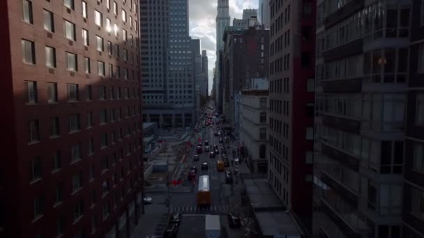 Воздушное движение на Бродвейской улице. В одну сторону дорога между высотными зданиями в центре города. Манхэттен, Нью-Йорк, США — стоковое видео