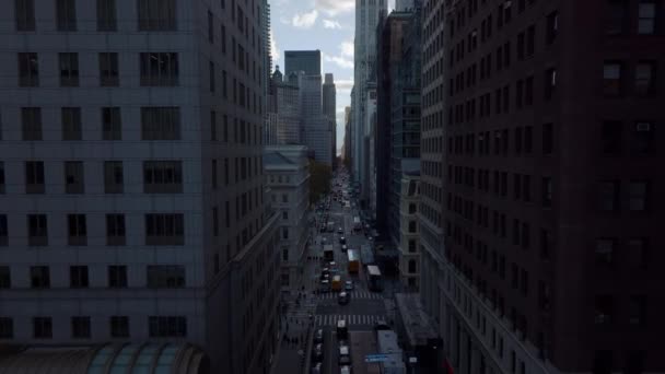 Para trás revelam de uma rua de sentido único entre edifícios altos da cidade. Estrada à parte no estaleiro. Manhattan, Nova Iorque, EUA — Vídeo de Stock