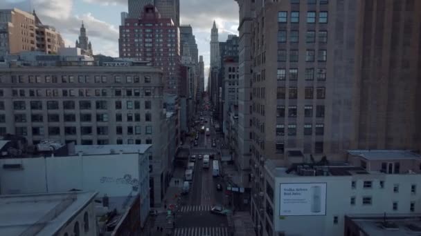 Wielopasmowa ulica jednokierunkowa pomiędzy wielopoziomowymi budynkami miejskimi. Przód przelatuje nad Broadway Street. Manhattan, Nowy Jork, USA — Wideo stockowe