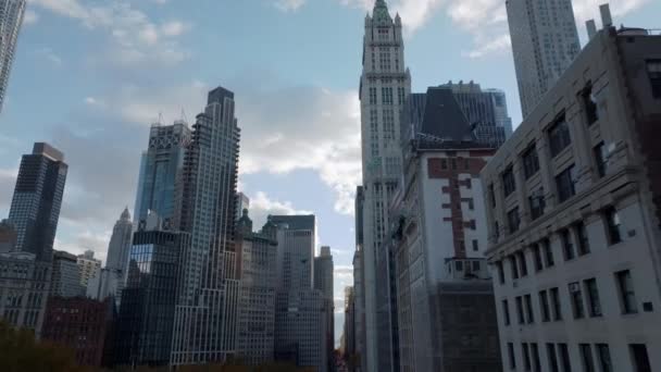 Вид с низкого угла на высокие небоскребы в центре города. Наклон вниз показывает улицу вдоль парка. Манхэттен, Нью-Йорк, США — стоковое видео
