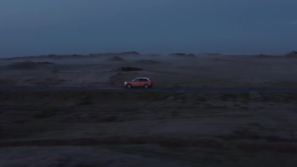 Widok z góry z drona samochodu autostrady pokojowo jazdy w godzinach wieczornych. Samochód z widokiem z powietrza jadący po pustej wiejskiej drodze o zachodzie słońca — Wideo stockowe