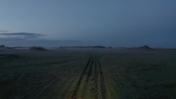 Вид з повітря летить в бік пригодницької машини, їдучи по дикій стежці в Ісландії в сільській місцевості. Комерційний вид з повітря туристів, які подорожують зеленуватися в Ісландії з боку дорожнього огляду дикої природи вночі. — стокове відео