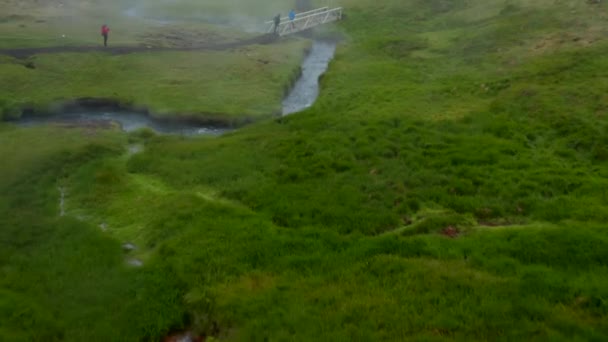 Drone vista sentiero turistico a piedi in Reykjadalur Islanda valle nella nebbia giorno. Birds eye of hot spring piscina fumante nella campagna erbosa islandese. Terme naturali a Golden Circle — Video Stock