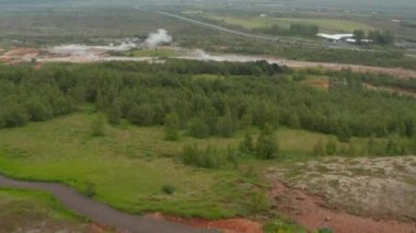 İzlanda 'daki Geysir Vadisi' nin havadan görünüşü, Altın Daire 'nin en ünlü cazibesi. Strokkur gayzer ve turistinin patlamayı beklediği sıcak kraterlerin insansız hava aracı görüntüsü. Seyahat hedefi