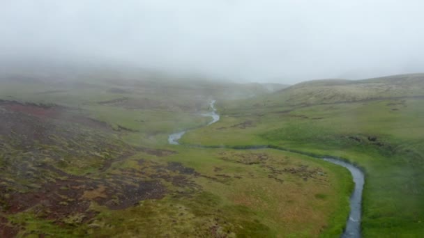 Vue des oiseaux sur la vallée des piscines de la rivière Reykjadalur par temps brumeux. Vue imprenable sur drone de la rivière chaude géothermique en Islande campagne verdoyante — Video