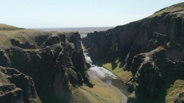 İzlanda 'da nehrin yavaşça aktığı kanyonun havadan nefes kesici manzarası. Yeşil yosunlarla kaplı İzlanda kanyonunda uçan insansız hava aracı görüntüsü inanılmaz. Doğada güzellik