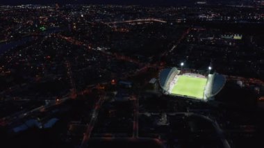 Parlak futbol sahasının muhteşem görüntüsü gece şehriyle çelişiyor. Yeşil futbol sahasında parlak bir ışık parlıyor. Limerick, İrlanda