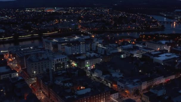 Vista aérea de vários edifícios da cidade. Rio Shannon fluindo calmamente pela cidade noturna. Limerick, Irlanda — Vídeo de Stock