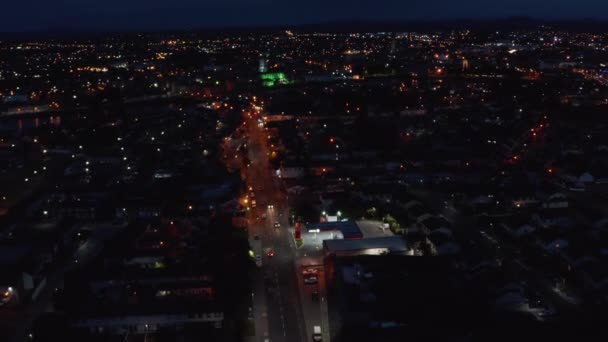 Панорамный снимок ночного города. Машины едут по улицам. Вперед летят над городским районом. Лимерик, Ирландия — стоковое видео