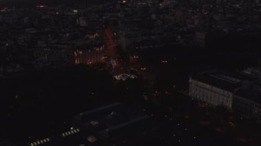 Akşam kasabasından geçen arabanın hava görüntüsü. Parlak gökyüzü ile karanlık alacakaranlık sahnesi.