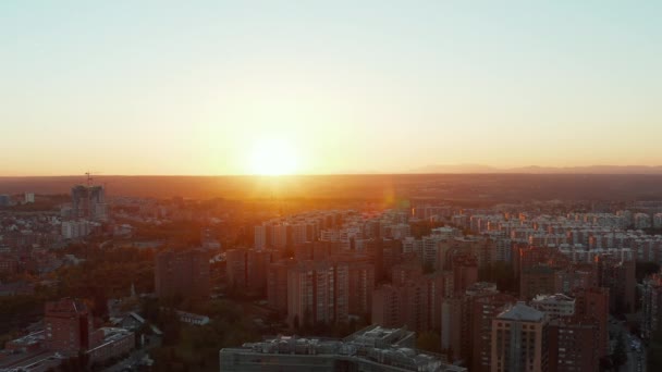 Voar para trás acima da cidade grande. Vista aérea de casas de apartamentos de vários andares na propriedade de habitação contra o pôr do sol. — Vídeo de Stock