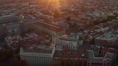 Şehir merkezindeki binaların hava görüntüleri. Yukari egilmek sehri ortaya çikarir ve günes ufukta batar.