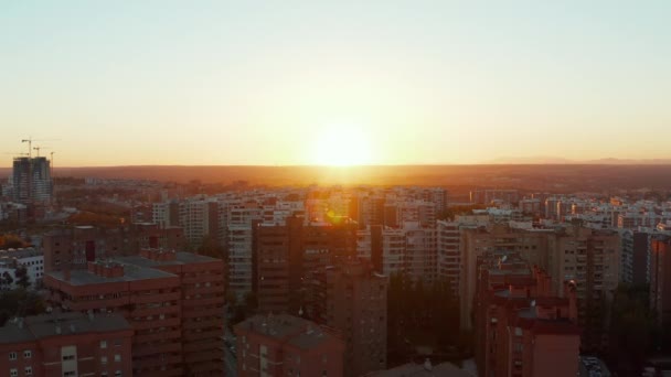 Bakåt visar sig byggnader på stora bostadsområden. Romantisk antenn vy mot färgglad solnedgång. — Stockvideo