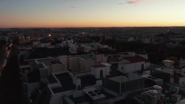 Fly above evening town. Various buildings in urban neighbourhood after sunset. Colourful twilight sky. — Stock Video