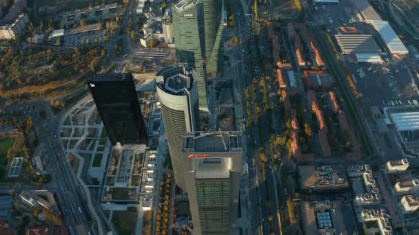 Wysoki kąt widzenia nowoczesnych wysokich budynków biurowych wznoszących się wysoko nad miastem. Pojazdy jeżdżące po drogach. Wieczorny widok z powietrza Cuatro Torres. — Wideo stockowe