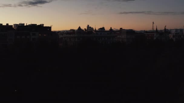 Rostoucí záběr zšeřelých budov v městské čtvrti. Odhalující večerní městská krajina proti romantické zlaté obloze západu slunce. — Stock video