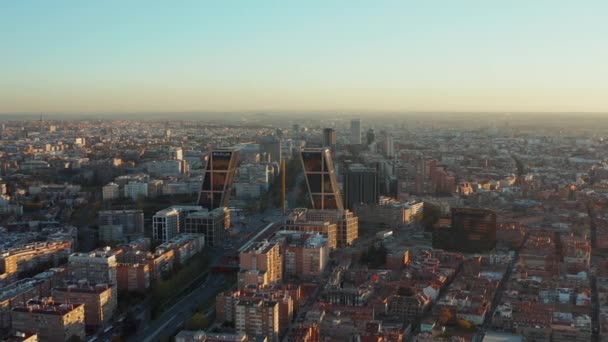 Diapositiva y panorámica de las modernas torres de negocios Puerta de Europa. Volar por encima de la ciudad al atardecer. — Vídeo de stock
