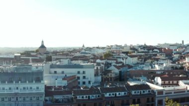 Şehir çevresindeki binaların üzerinde ilerliyorlar. Dar sokaklar boyunca çok katlı binalar.