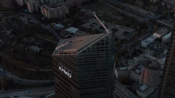 Filmagem aérea ascendente do topo do arranha-céu moderno no complexo CTBA após o pôr-do-sol. Edifício de escritórios elevando-se acima da cidade. — Vídeo de Stock