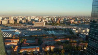 Geriye dönük modern gökdelenler. Parlak cam cephe şehir gelişimini ve gökyüzünü yansıtıyor. Işıl ışıl güneş ışığı.