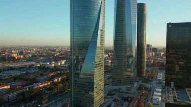 Cuatro Torres İş Alanındaki modern cam ofis kulelerinin kaydırma ve pan görüntüleri. Trafikle dolu uzun ve düz bir bulvar ortaya çıkıyor..