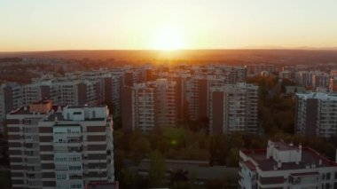 Konutların üzerinden uçmak, çok katlı prefabrik apartman binalarını açığa çıkarmak. Batan güneşe karşı hava görüntüsü.