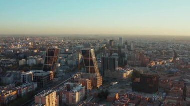 Gece güneş ışığında şehrin iş bölgesinin üzerinde ilerliyorlar. Plaza de Castilla Meydanı 'ndaki yassı ofis ikiz kuleleri.