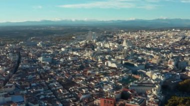 Şehir manzarasının havadan çekilmiş panoramik görüntüleri. Şehir merkezinde çeşitli binalar var. Dağ mesafesi.