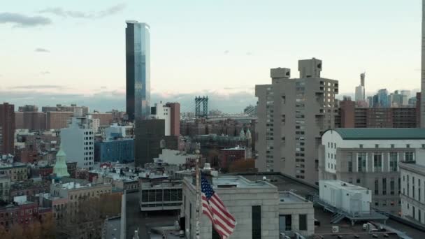 Hacia adelante vuelan alrededor de la bandera de Estados Unidos en el polo. Filmación de grandes edificios municipales de gran altura y rascacielos en el fondo. Manhattan, Nueva York, Estados Unidos — Vídeos de Stock