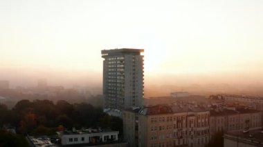 Mlotek apartmanının kayma ve pan görüntüleri. Sisin arkasından doğan güneşe karşı uzun prefabrik. Varşova, Polonya