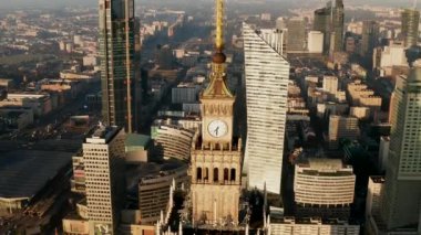 Yükseklerdeki PKIN binasının tepesinde kule kulesinin havadan inen görüntüleri. Arka planda modern yüksek binalar. Varşova, Polonya